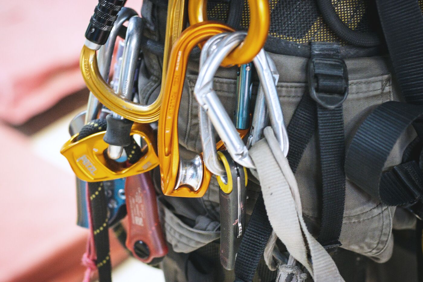 Close-up of carabiners, descenders and slings racked on a rope access harness.